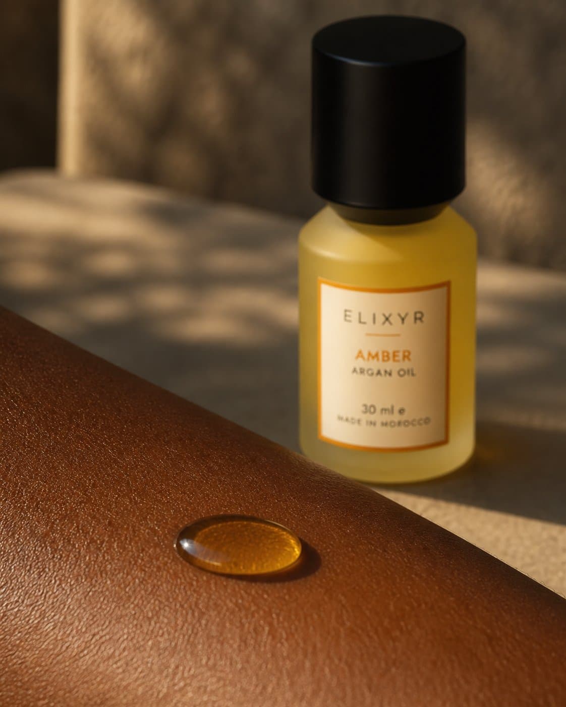 A golden bead of argan oil resting on skin